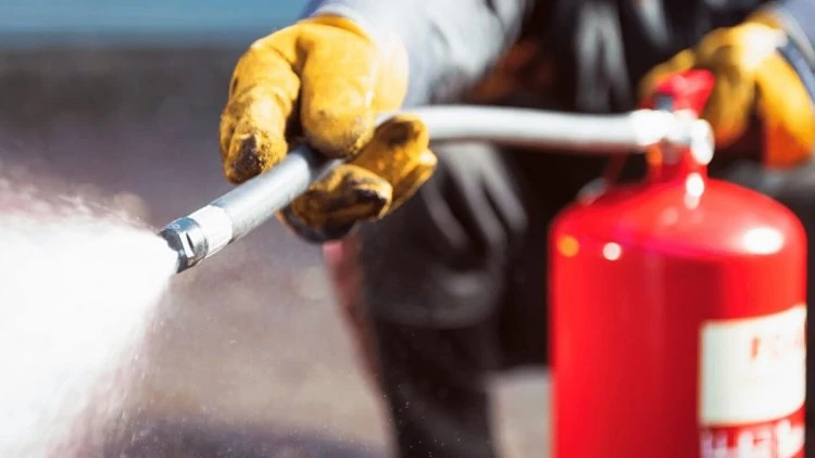 Extintor en uso durante revisión técnica en Huelva | Extintores A2J Técnico de Extintores A2J realizando mantenimiento y prueba de extintor en Huelva